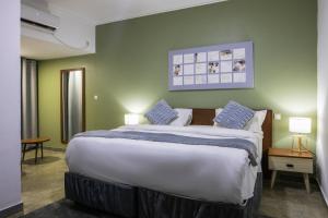 a large bed in a room with green walls at Aylane Hotel in Nampula