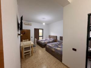 a room with a bed and a desk and a table at Hotel Gjinaj in Shëngjin