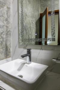 a white sink in a bathroom with a mirror at Aylane Hotel in Nampula