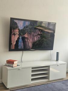 a white dresser with a picture on the wall at City Base Dortmund in Dortmund
