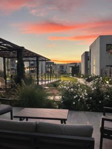 a sunset over a building with a couch and a table at Terruar Wine in Ciudad Lujan de Cuyo