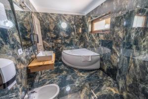 a bathroom with a tub and a sink at Pensiunea Seraris in Voineasa +70 photos