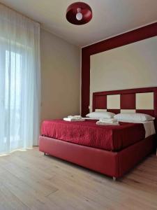 a bedroom with a large bed with a red headboard at marte rooms in Centola +54 photos