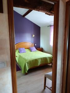a bedroom with a green bed with purple walls at Gîte Matran in Cauna