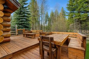 a wooden deck with benches and tables on it at Pinedale Cabin in McCall