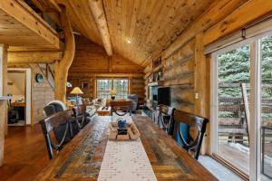 a dining room with a long table and chairs at Pinedale Cabin in McCall +18 photos