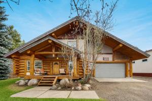 a log home with a garage in front of it at Pinedale Cabin in McCall