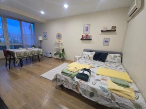a bedroom with a bed and a table in it at Grand and Prime Central Apartments Varna in Varna City