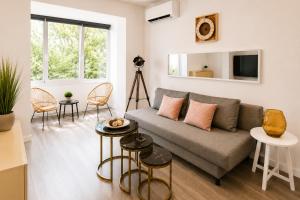 a living room with a couch and two tables at Metropole Apartments Romana Square in Bucharest