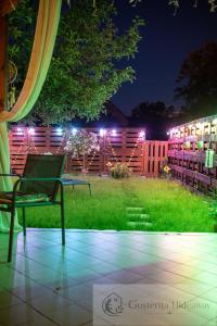 a yard with a chair and a fence at night at Gusterita Hideaway in Sibiu