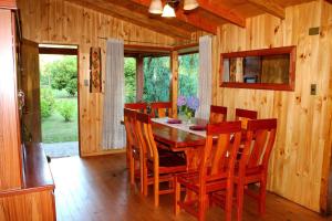 a wooden dining room with a wooden table and chairs at Parcela Peumayen casa 1 in Coñaripe