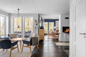 a living room with a table and chairs and a fireplace at Cat-Friendly Archipelago Villa in Nacka