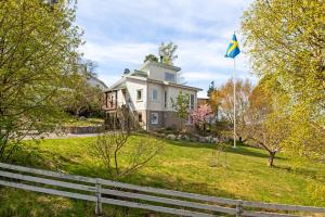 a house with a flag in the yard at Cat-Friendly Archipelago Villa in Nacka