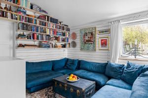 a living room with a blue couch and a table at Cat-Friendly Archipelago Villa in Nacka