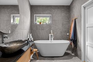 a bathroom with a large white tub and a sink at Cat-Friendly Archipelago Villa in Nacka +68 photos