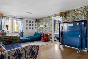 a living room with a blue couch and a large tv at Cat-Friendly Archipelago Villa in Nacka