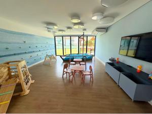 a room with a table and chairs and a mural at Nomar 208 pe na areia na Praia dos carneiros in Tamandaré