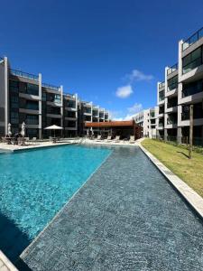 a swimming pool in front of a apartment building at Nomar 208 pe na areia na Praia dos carneiros in Tamandaré