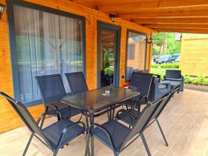 a black table and chairs on a patio at Drina Escape - Lake View in Višegrad +21 photos