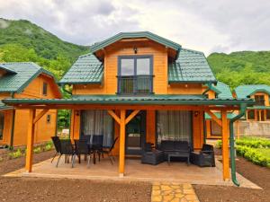 a house with a large deck with a roof at Drina Escape - Lake View in Višegrad