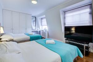 a hotel room with two beds and a flat screen tv at Boltons Residence Collection Hotel London in London