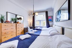 a bedroom with three beds and a dresser at Boltons Residence Collection Hotel London in London +19 photos