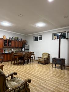 a living room with a table and chairs and a kitchen at Konstanta in Lentekhi