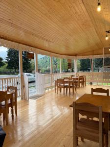 a dining room with wooden tables and chairs at Konstanta in Lentekhi