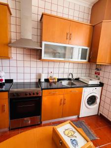 a kitchen with wooden cabinets and a sink and a dishwasher at GARDEN VIEW APARTMENT in Horta