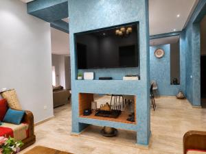 a living room with a fireplace with a tv above it at Family fun farm - Évasion Nature - piscine et ferme in Berrechid