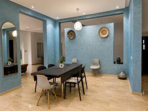 a dining room with blue walls and a table and chairs at Family fun farm - Évasion Nature - piscine et ferme in Berrechid