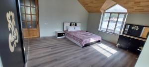 a bedroom with a bed and a large window at Comfort Hills in İsmayıllı
