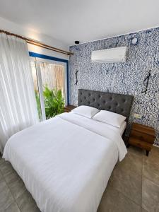 a bedroom with a large white bed and a window at Villa Dalaman Müjgan Hanım Konağı in Dalaman