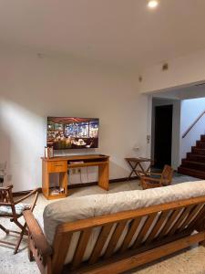 a living room with a couch and a flat screen tv at Tranquilidad en Bragado in Bragado