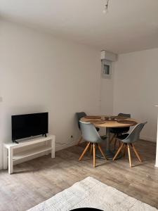 a living room with a table and a tv at La Parenthèse Calme in Tours