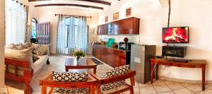 a living room with a couch and a table and a refrigerator at Garden Level Studio in Mtwapa
