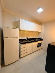 a kitchen with white cabinets and a white refrigerator at Casa Maestro Tristão in Franca +8 photos
