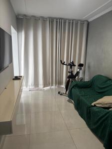 a bedroom with a bike in a room with a television at Casa Maestro Tristão in Franca