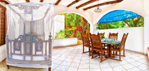 a patio with a table and chairs and an umbrella at Garden Level Studio in Mtwapa