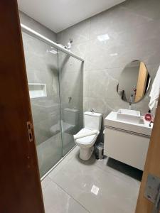 a bathroom with a shower and a toilet and a sink at Casa Maestro Tristão in Franca