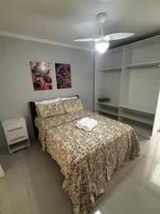 a bedroom with a bed with a flowered bedspread at Casa Maestro Tristão in Franca
