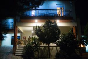 a building with a balcony at night at Voras Apartments in Kato Loutraki