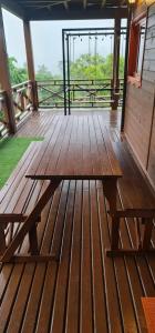 a wooden picnic table on a deck with a view at Chalé Vale das Montanhas in Timbe do Sul
