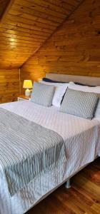 a large bed in a room with a wooden ceiling at Chalé Vale das Montanhas in Timbe do Sul