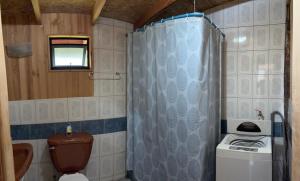 a small bathroom with a toilet and a shower at Parcela Peumayen casa 3 in Pucura