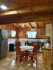 a kitchen with a table and chairs and a refrigerator at Parcela Peumayen casa 3 in Pucura +14 photos