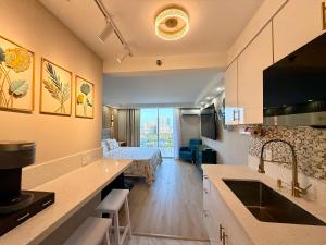 a kitchen with a sink and a living room at Inn On The Park in Honolulu