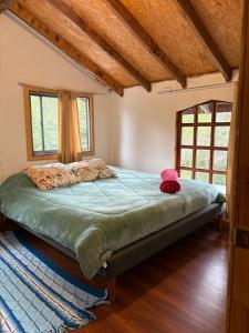 a bedroom with a bed in a room with windows at Parcela Peumayen casa 3 in Pucura