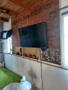 a flat screen tv hanging on a brick wall at El olivo apart in City Bell