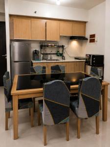 a kitchen with a table and chairs in a kitchen at Davao City Stay at Camella Northpoint Spacious 3BR Condo 5Beds Up to 10 Guests in Davao City +11 photos